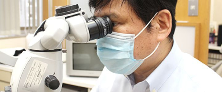 マイクロスコープを使用中のとかじ院長